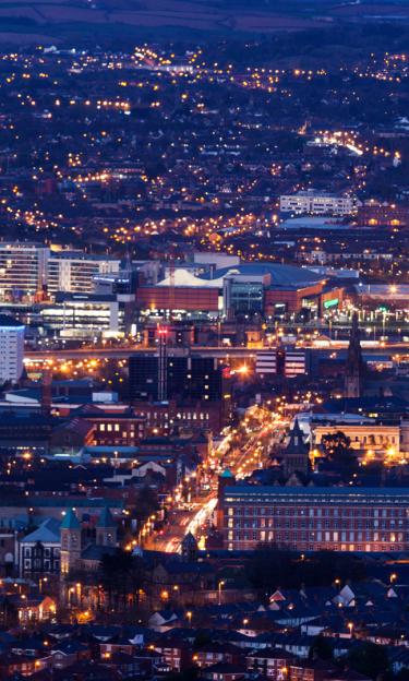 Image features the city of Belfast at night.